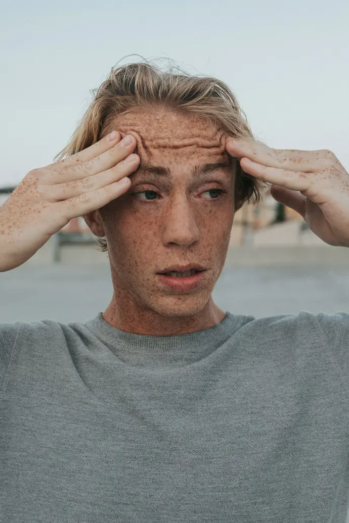 Hombre con camiseta gris de cuello redondo y cabello castaño